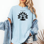 Namaste T-shirt featuring a serene yoga-inspired design with a silhouette of a person meditating in a lotus pose. Behind the figure is a stylized lotus flower, symbolizing peace, balance, and mindfulness. Printed on a soft, relaxed unisex tee, this calming graphic is perfect for yoga lovers, meditation enthusiasts, and anyone embracing a mindful lifestyle focused on inner peace and spiritual wellness.