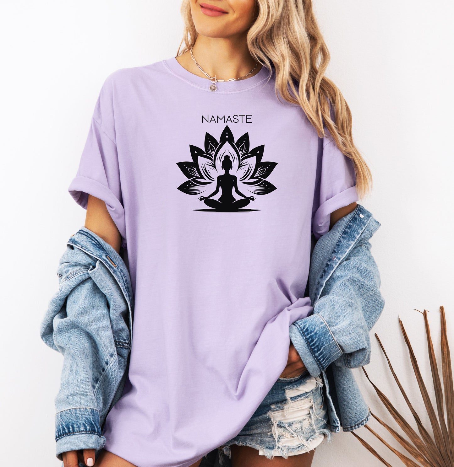 Namaste T-shirt featuring a serene yoga-inspired design with a silhouette of a person meditating in a lotus pose. Behind the figure is a stylized lotus flower, symbolizing peace, balance, and mindfulness. Printed on a soft, relaxed unisex tee, this calming graphic is perfect for yoga lovers, meditation enthusiasts, and anyone embracing a mindful lifestyle focused on inner peace and spiritual wellness.