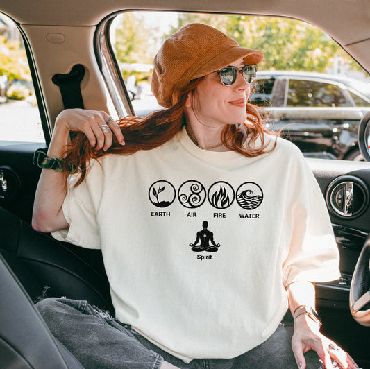 Ivory t-shirt featuring a minimalist Nature’s Elements design with black icons representing Earth, Air, Fire, and Water in circular symbols, with a meditating figure below symbolizing Spirit. Perfect for yoga, meditation, mindfulness, balance, and nature lovers. Relaxed fit, casual boho style.