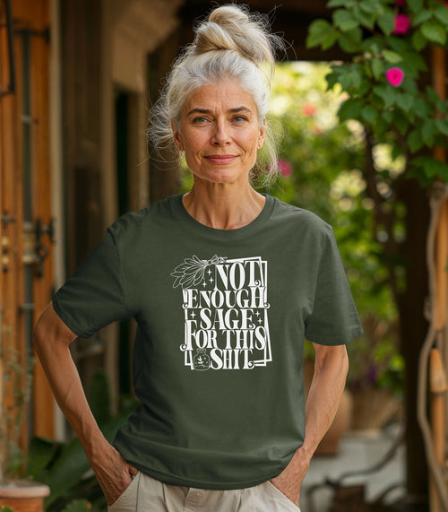 Hemp color T-shirt with bold white typography reading “Not Enough Sage For This Shit,” accented with illustrated sage leaves, sparkles, and a small potion jar with a leafy design. Playful and cheeky statement shirt for spiritual, witchy, or humor-loving personalities.