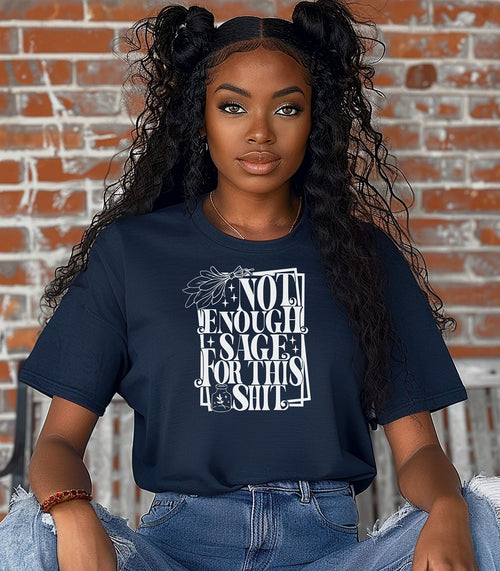 True Navy T-shirt with bold white typography reading “Not Enough Sage For This Shit,” accented with illustrated sage leaves, sparkles, and a small potion jar with a leafy design. Playful and cheeky statement shirt for spiritual, witchy, or humor-loving personalities.