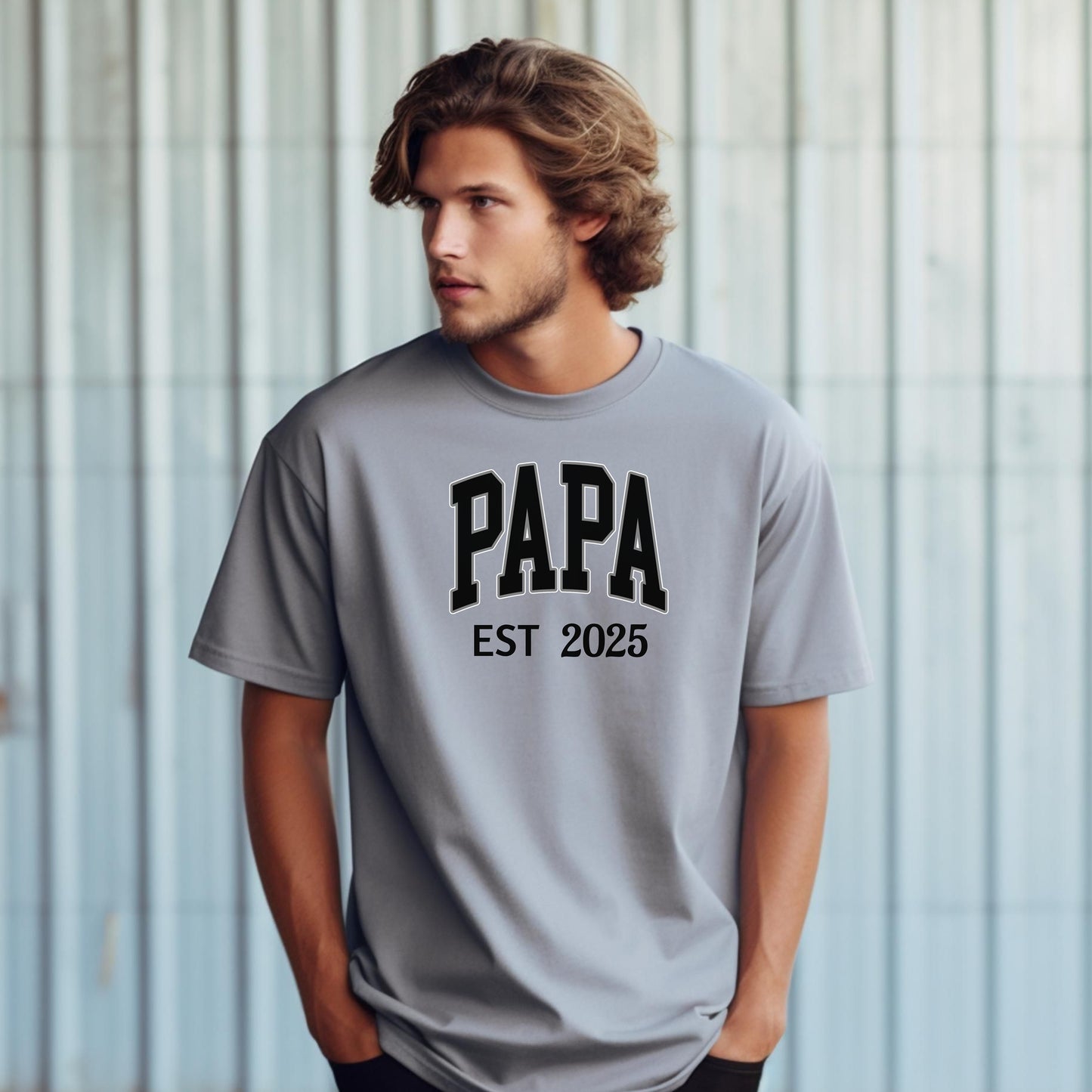 PAPA Est [Year] T-shirt featuring bold collegiate-style lettering with a customizable establishment year. Printed on a soft, relaxed-fit unisex tee in a granite color, this design makes a perfect gift for new grandfathers, Father’s Day, or family celebrations. Ideal for proudly announcing the year someone became 'Papa' while offering comfort and casual style.