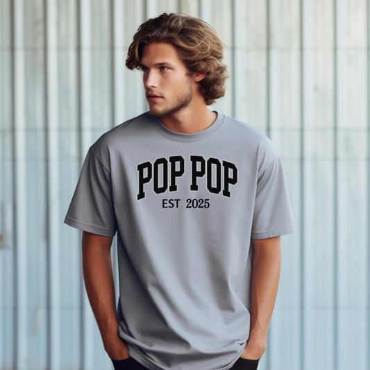 POP POP Est [Year] T-shirt featuring bold varsity-style lettering with a customizable establishment year. Displayed on a soft, granite unisex tee, this casual design is perfect for celebrating a new grandfather or marking a special year. Ideal for Father’s Day, birthdays, or family gatherings, it combines comfort with a proud, personalized statement.