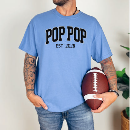 POP POP Est [Year] T-shirt featuring bold varsity-style lettering with a customizable establishment year. Displayed on a soft, mystic blue unisex tee, this casual design is perfect for celebrating a new grandfather or marking a special year. Ideal for Father’s Day, birthdays, or family gatherings, it combines comfort with a proud, personalized statement.