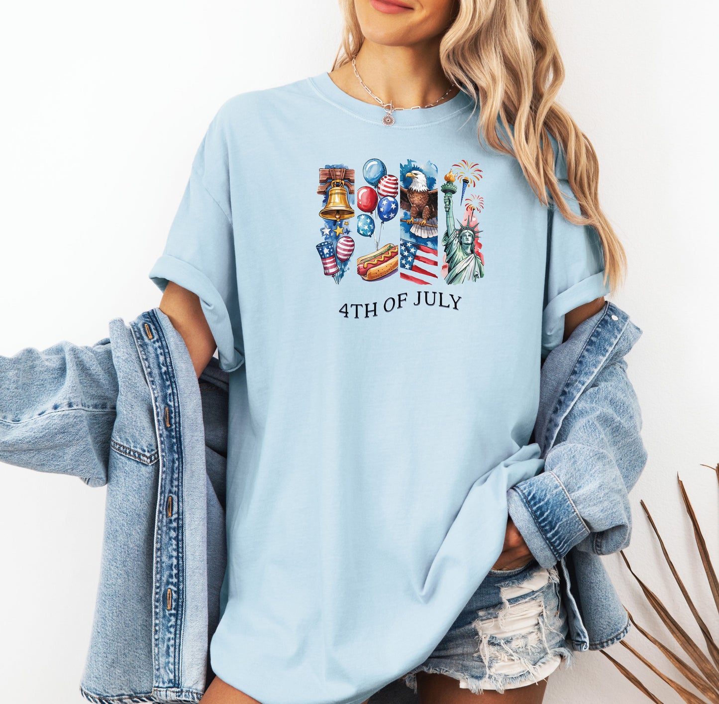 Chambray light blue t-shirt with '4th of July' design, worn by a person with a denim jacket and shorts.