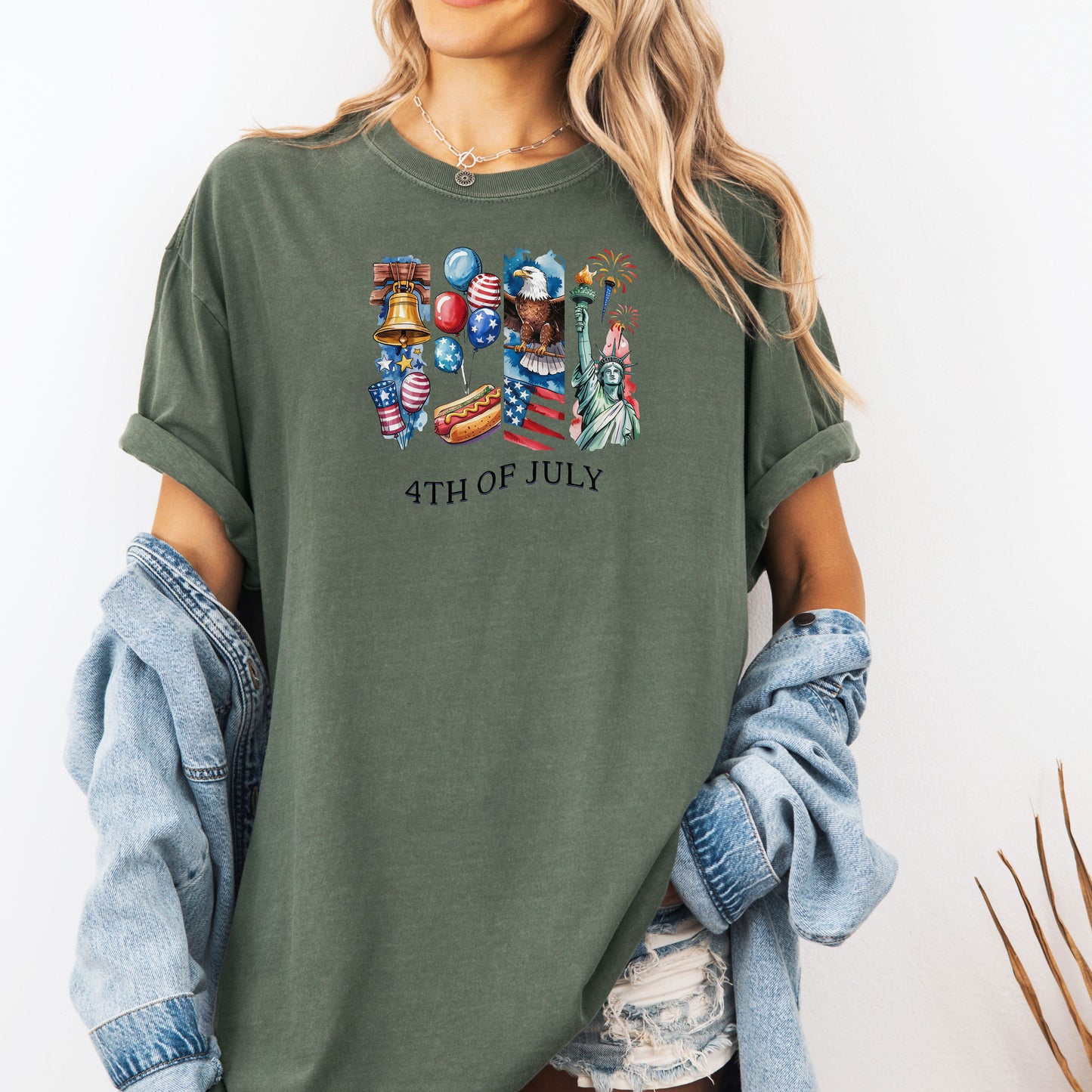 Person wearing a Moss green t-shirt with '4th of July' graphics and text.