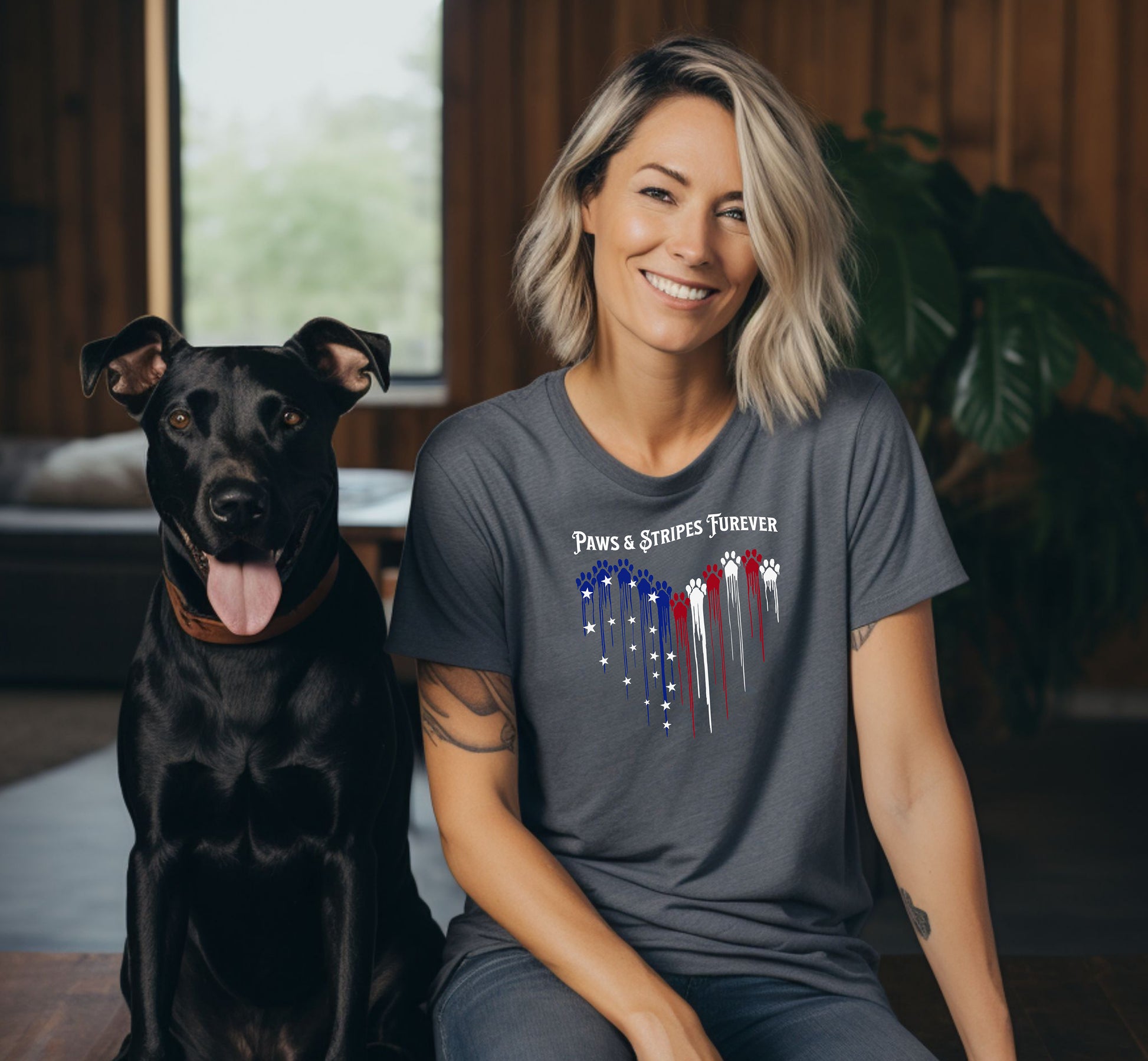 A person wearing a pepper T-shirt featuring a heart-shaped design made of dripping red, white, and blue paw prints with star accents. Above the heart, the text reads “Paws & Stripes Furever,” blending patriotic pride with a love for pets, making it a perfect shirt for animal lovers and USA enthusiasts.