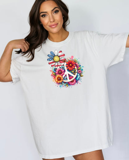 White t-shirt featuring a vibrant retro Peace Love Liberty design with a large white peace sign surrounded by colorful flowers. A daisy with red, white, and blue American flag petals stands out, blending patriotic style with boho hippie vibes. Perfect for 4th of July, festivals, and casual summer wear.