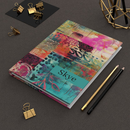 Personalized Boho Hardcover Journal with name text on a dark surface with office supplies.