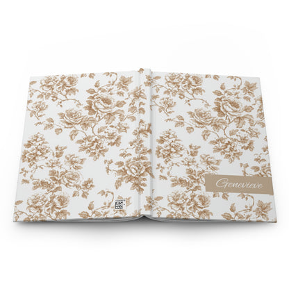 Personalized hardcover journal with champagne floral toile pattern on a white background, featuring the name 'Genevieve' lying face down showing front and back covers.