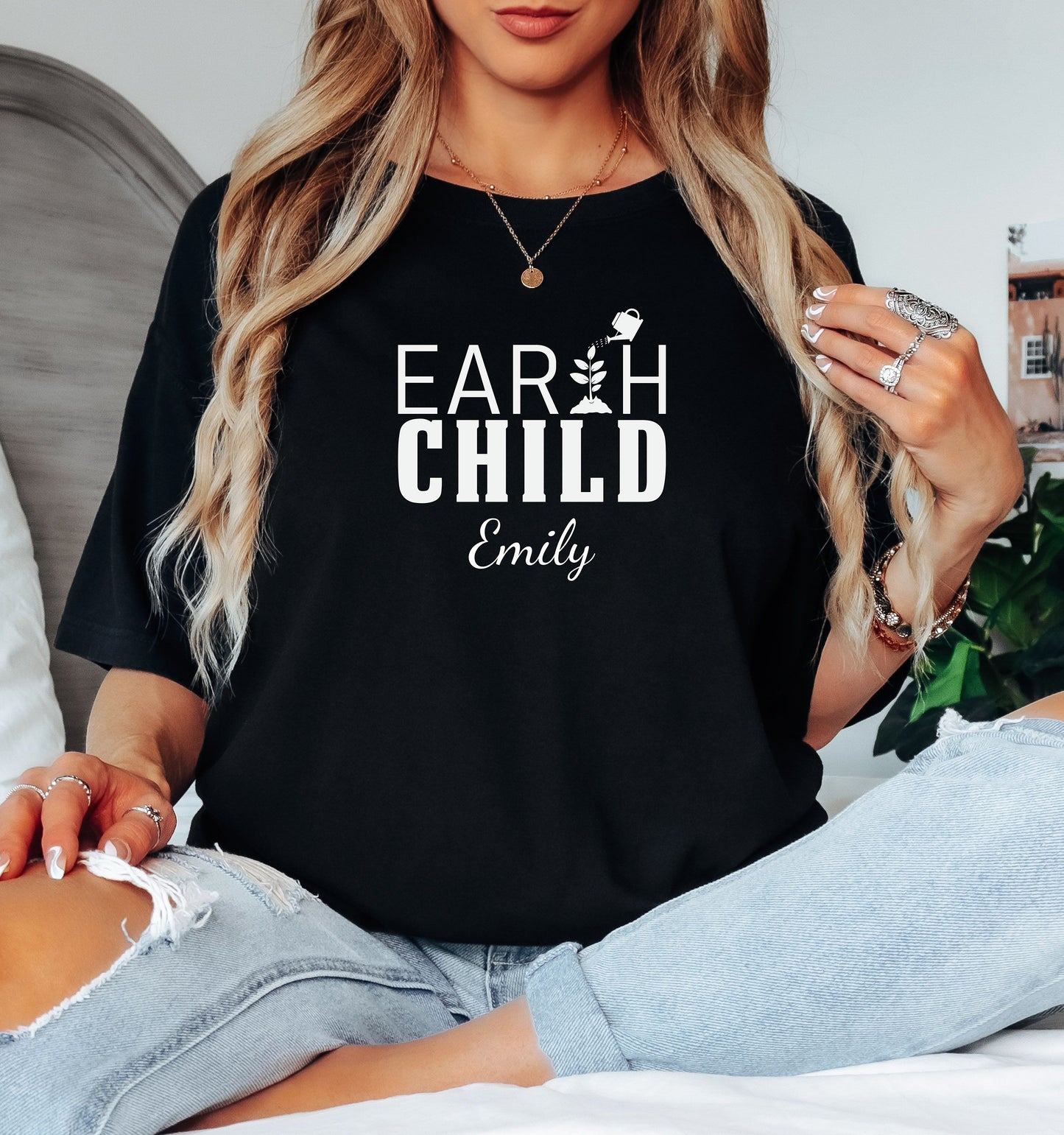 Personalized Earth Child T-shirt featuring a stylish nature-inspired design. The shirt displays the words 'EARTH CHILD' with a plant sprouting from the letter T being watered by a small watering can, symbolizing growth and love for nature. Customizable with a name below the text, this soft, casual unisex tee is perfect for eco-conscious individuals, gardeners, and free spirits who embrace a sustainable and earthy lifestyle.