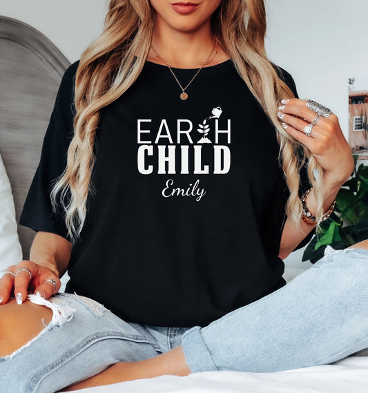 Personalized Earth Child T-shirt featuring a stylish nature-inspired design. The shirt displays the words 'EARTH CHILD' with a plant sprouting from the letter T being watered by a small watering can, symbolizing growth and love for nature. Customizable with a name below the text, this soft, casual unisex tee is perfect for eco-conscious individuals, gardeners, and free spirits who embrace a sustainable and earthy lifestyle.