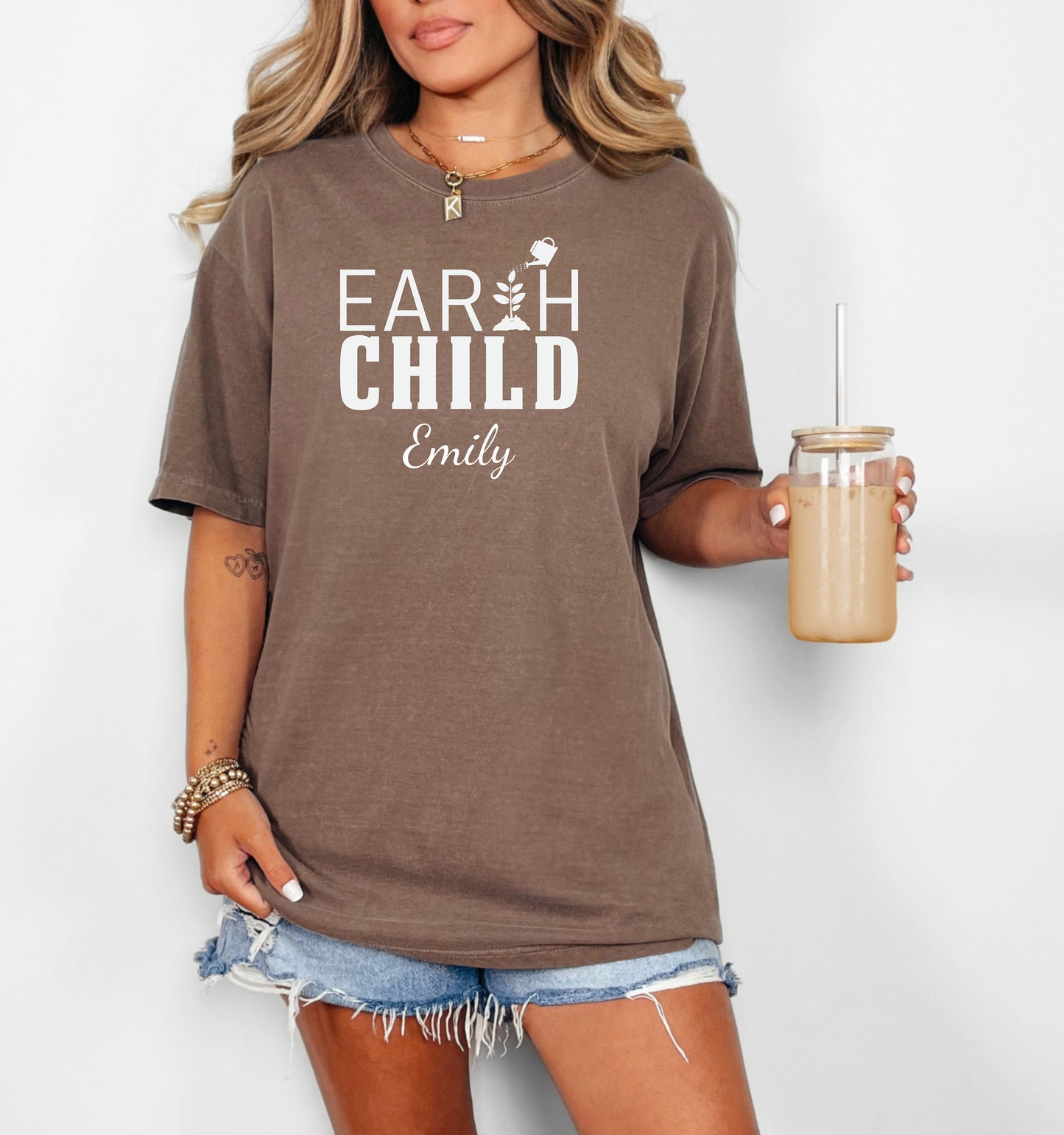 Personalized Earth Child T-shirt featuring a stylish nature-inspired design. The shirt displays the words 'EARTH CHILD' with a plant sprouting from the letter T being watered by a small watering can, symbolizing growth and love for nature. Customizable with a name below the text, this soft, casual unisex tee is perfect for eco-conscious individuals, gardeners, and free spirits who embrace a sustainable and earthy lifestyle.