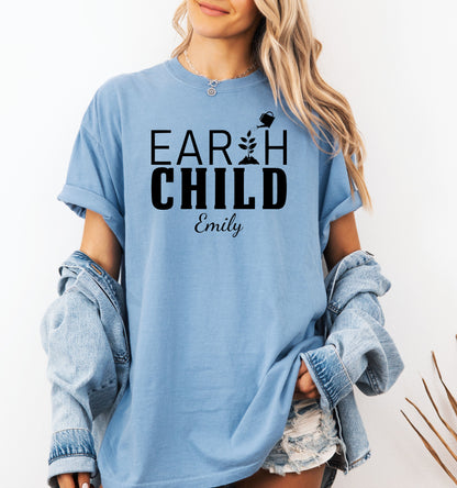 Personalized Earth Child T-shirt featuring a stylish nature-inspired design. The shirt displays the words 'EARTH CHILD' with a plant sprouting from the letter T being watered by a small watering can, symbolizing growth and love for nature. Customizable with a name below the text, this soft, casual unisex tee is perfect for eco-conscious individuals, gardeners, and free spirits who embrace a sustainable and earthy lifestyle.