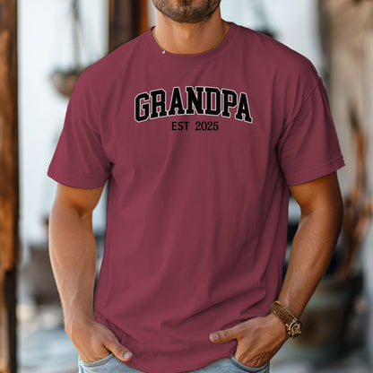 Chili t-shirt featuring a bold collegiate-style 'GRANDPA EST [Year]' design in black and white lettering. Perfect gift for new grandfathers to celebrate the year they became a grandpa. A thoughtful, casual, and comfortable shirt ideal for Father's Day, family gatherings, or everyday wear.