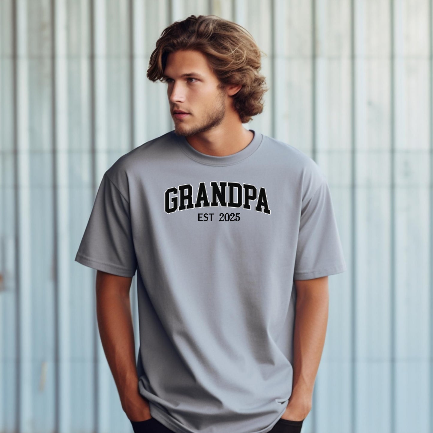 Granite t-shirt featuring a bold collegiate-style 'GRANDPA EST [Year]' design in black and white lettering. Perfect gift for new grandfathers to celebrate the year they became a grandpa. A thoughtful, casual, and comfortable shirt ideal for Father's Day, family gatherings, or everyday wear.