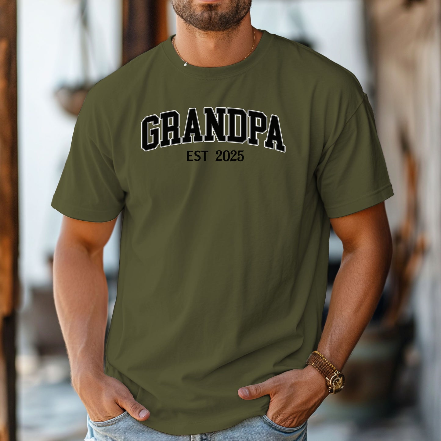 Hemp color t-shirt featuring a bold collegiate-style 'GRANDPA EST [Year]' design in black and white lettering. Perfect gift for new grandfathers to celebrate the year they became a grandpa. A thoughtful, casual, and comfortable shirt ideal for Father's Day, family gatherings, or everyday wear.