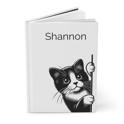 Open hardcover journal with a black and white cat illustration and the name on a white background
