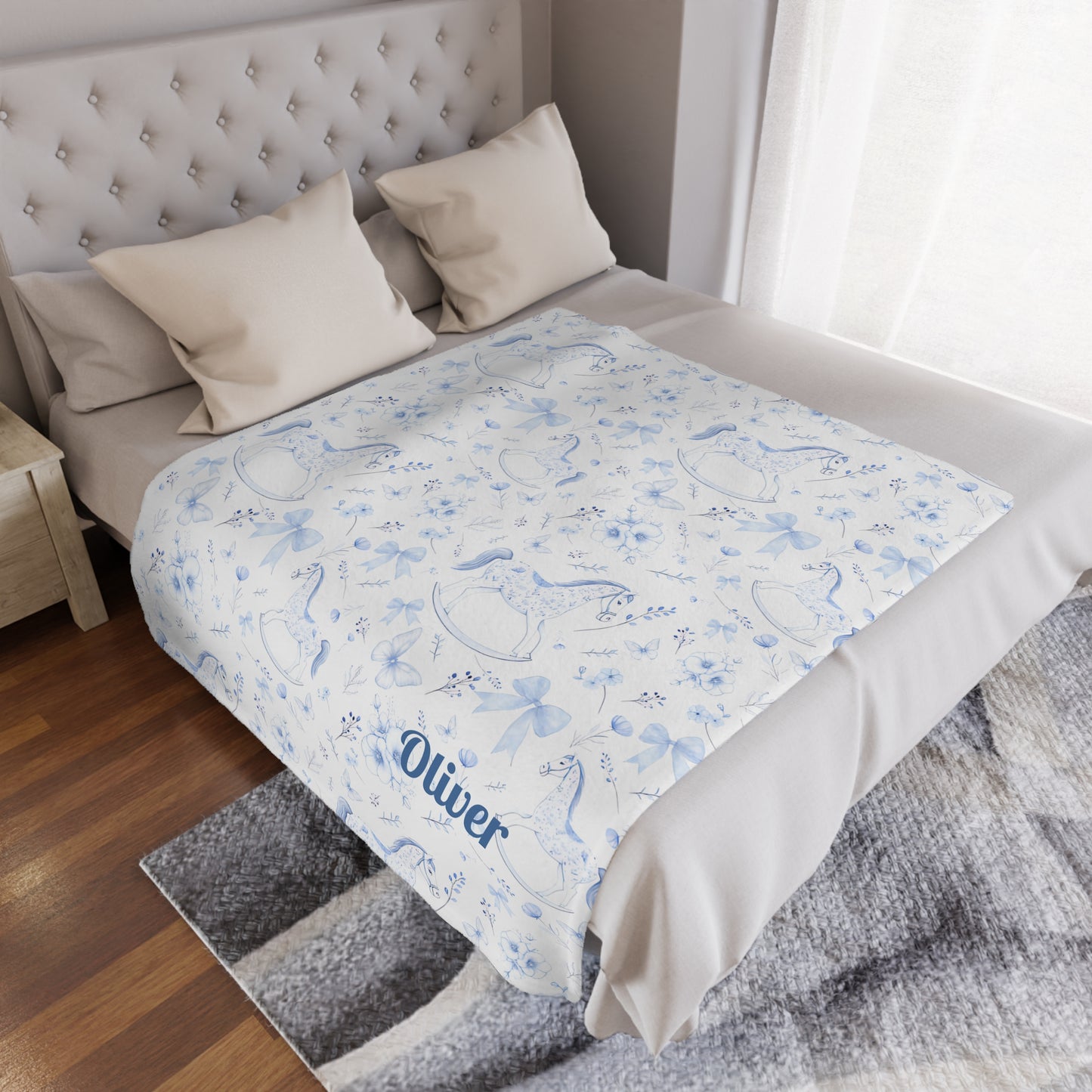 Personalized Rocking Horse Minky blanket with blue chinoiserie patterns and 'Oliver' text on a bed in a bedroom.