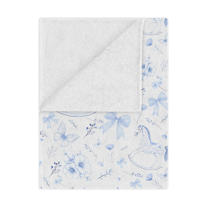 Personalized Rocking Horse Minky blanket with blue chinoiserie patterns and 'Oliver' text on a bed in a bedroom.