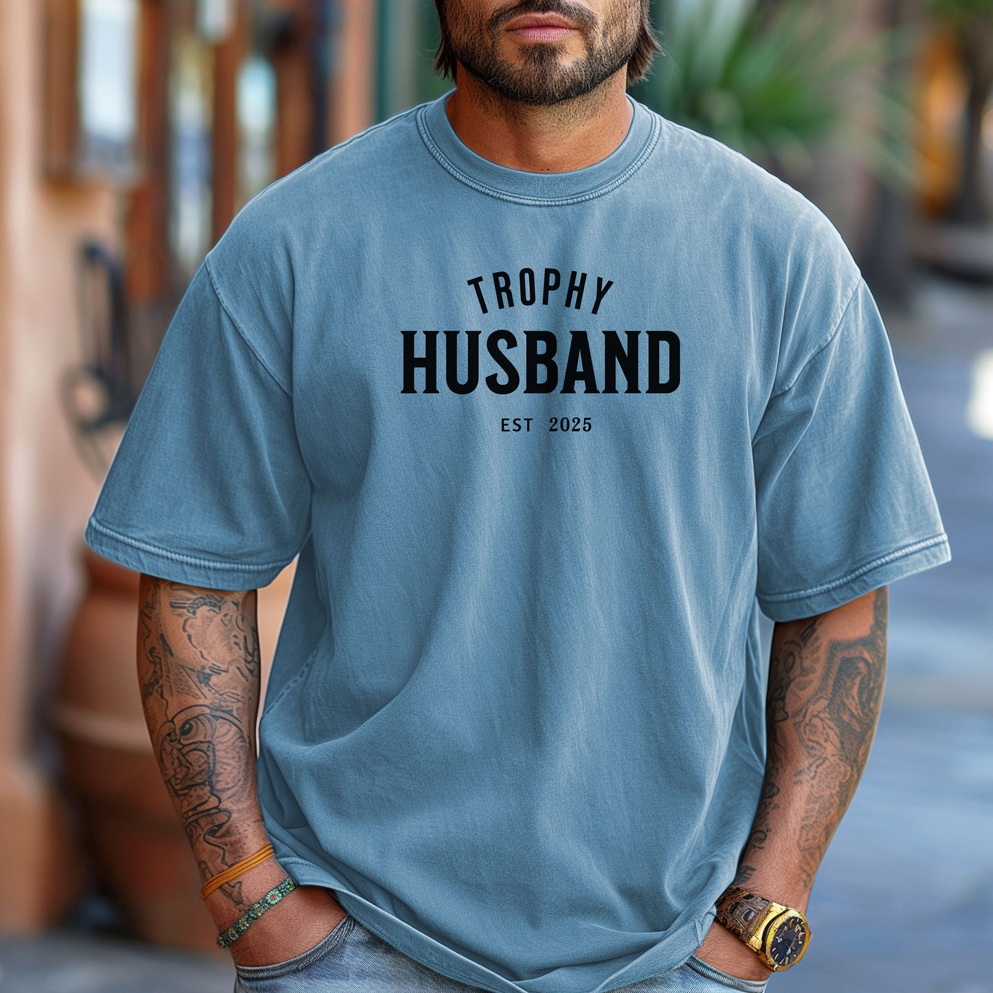 Washed Denim Trophy Husband EST [Year] graphic T-shirt featuring bold black typography on a casual crewneck shirt. Perfect gift for newlyweds, anniversaries, grooms, or husbands with a sense of humor. Comfortable, stylish, and great for everyday wear or special occasions to celebrate marriage and fun couple vibes.
