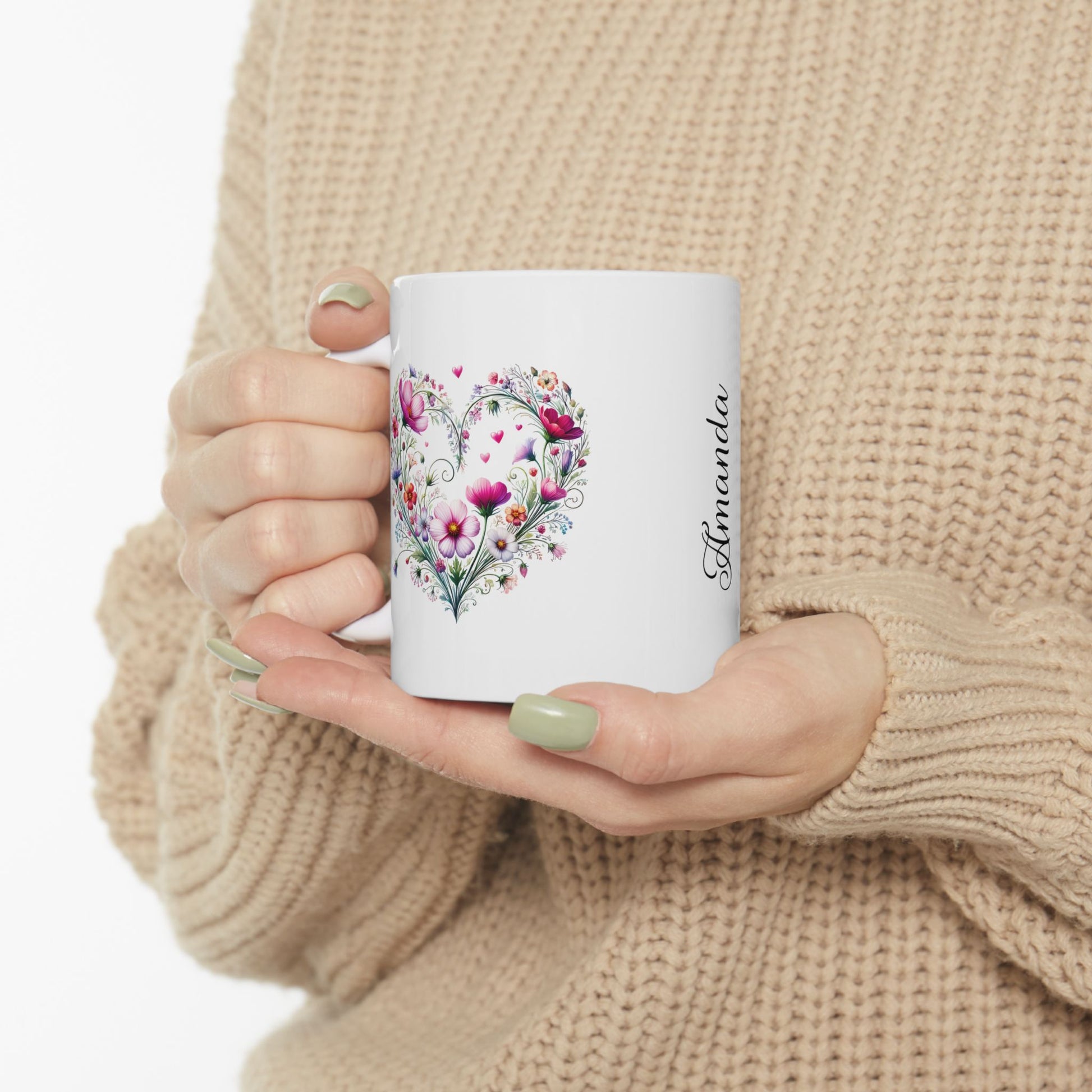Person holding a ceramic mug with a boho floral heart design and name Amanda' on a white background