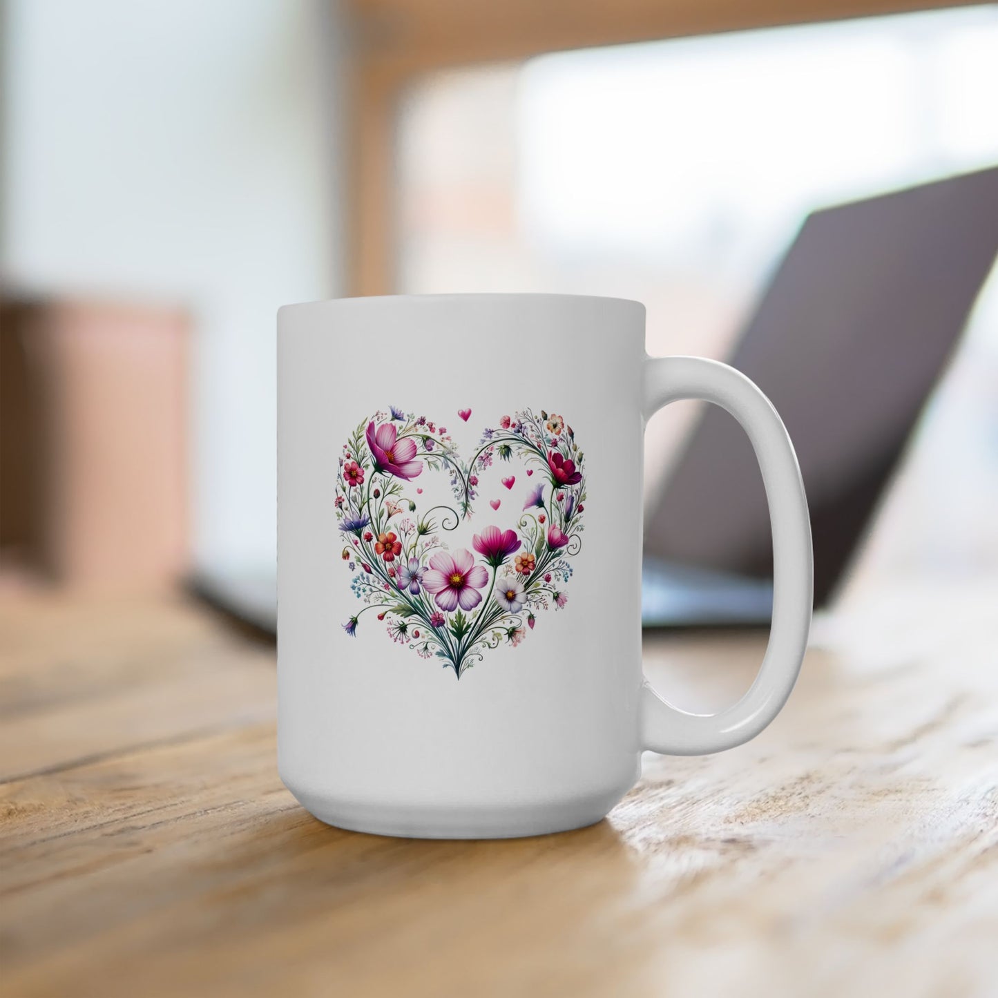 White ceramic mug with a floral wildflower boho heart design on a wooden surface