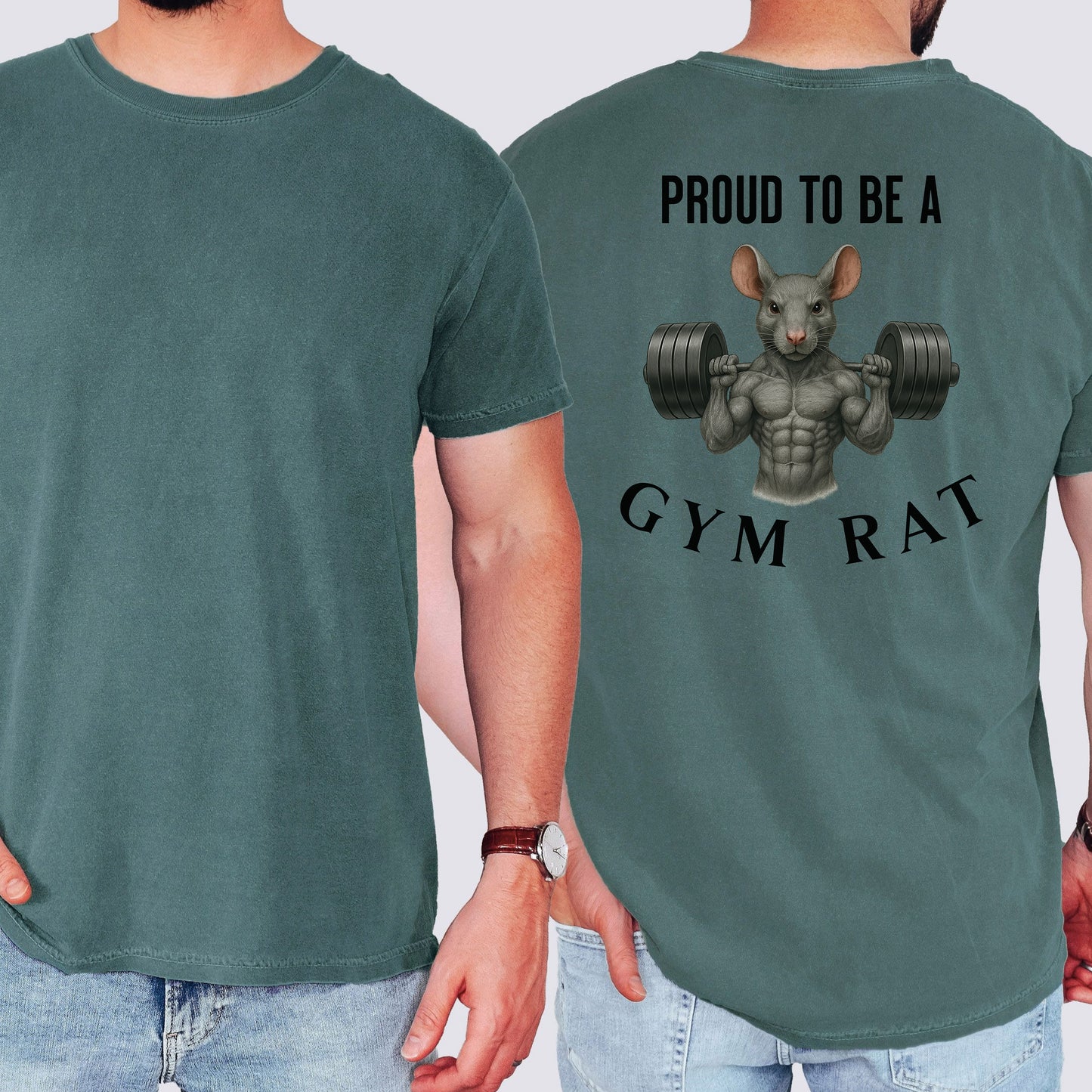 Person wearing a blue spruce T-shirt featuring a bold back design with the phrase “Proud to Be a Gym Rat” above and below a muscular cartoon rat holding heavy dumbbells. The strong, flexing rat graphic symbolizes dedication to fitness and weightlifting, making this shirt perfect for gym lovers, bodybuilders, and strength training enthusiasts.