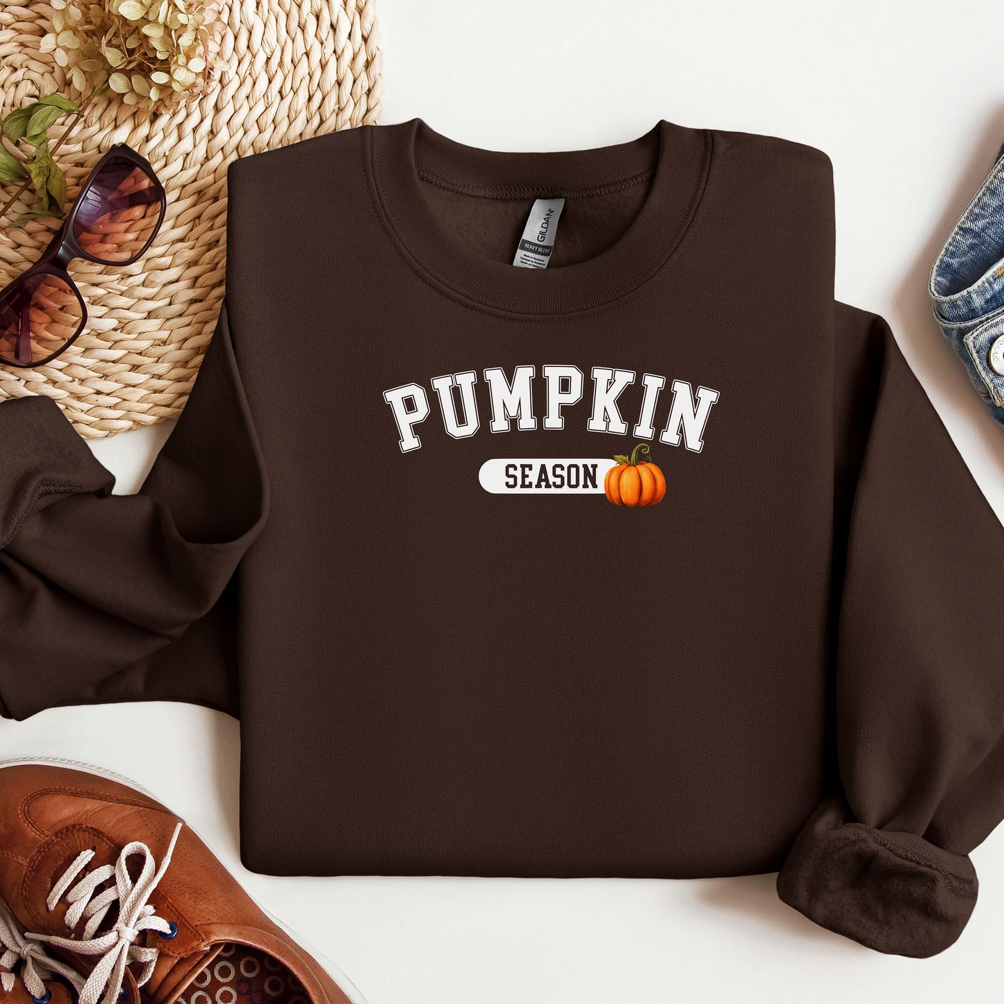 Dark Chocolate sweatshirt with 'Pumpkin Season' text and pumpkin graphic on a white surface with accessories.