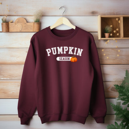 Maroon sweatshirt with 'Pumpkin Season' text and pumpkin graphic on a wooden background
