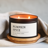 Pumpkin Spice Soy Wax Blend Candle in a 8 oz black matte candle tin with a wooden coaster on a light background