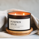 Pumpkin Spice Soy Wax Blend Candle in a 8 oz black matte candle tin with a wooden coaster on a light background