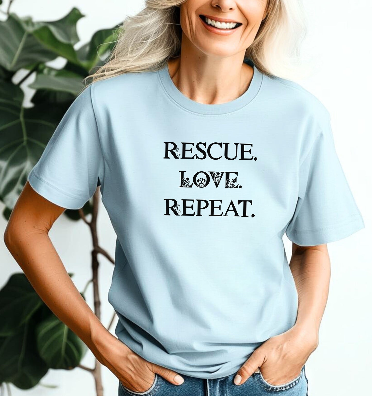 Rescue. Love. Repeat. T-shirt with bold black typography and cute kitten and puppy accents inside the letters. Shown on a chambray light blue unisex tee, this design is perfect for animal rescue advocates, pet lovers, and adoption supporters. Ideal for wearing to volunteer events, shelter fundraisers, or everyday outings to show pride in rescuing and loving animals.