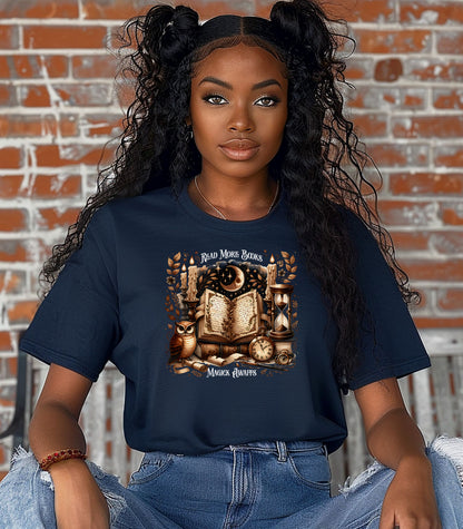 Person wearing a True Navy t-shirt featuring a whimsical "Read More Books, Magick Awaits" design. The graphic showcases an open enchanted book surrounded by candles, a crescent moon, owl, pocket watch, hourglass, and magical elements, creating a mystical and literary aesthetic perfect for book lovers and fantasy fans.