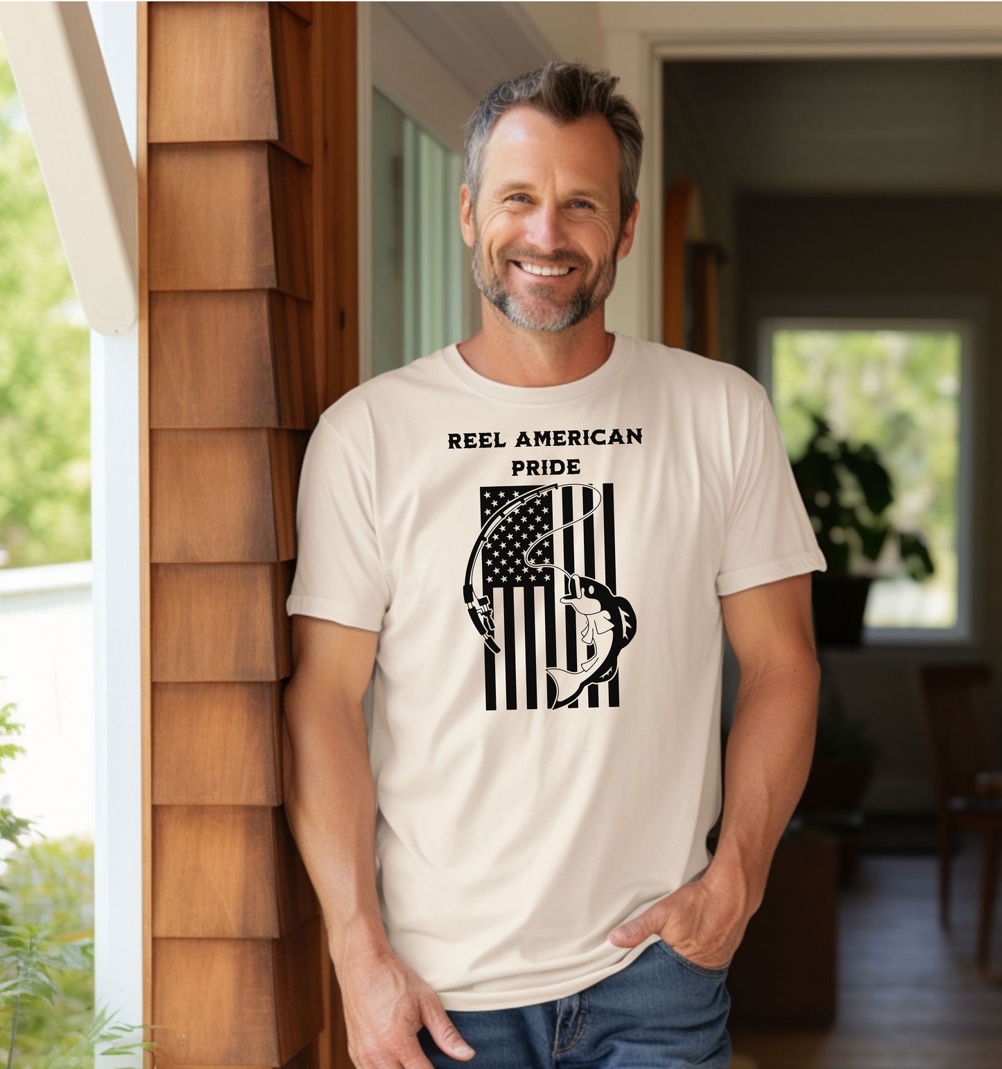 Reel American Pride T-shirt featuring a bold fishing-themed design with the phrase 'Reel American Pride' above an American flag graphic. A large fish is hooked on a fishing line overlaying the flag’s stripes. Printed on a classic ivory unisex tee, this patriotic fishing shirt is perfect for anglers who love both their country and the sport. Ideal for summer outings, fishing trips, or casual everyday wear.