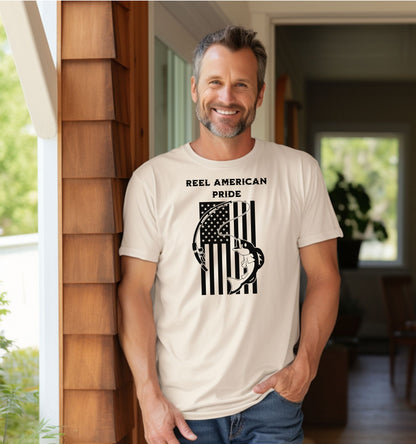 Reel American Pride T-shirt featuring a bold fishing-themed design with the phrase 'Reel American Pride' above an American flag graphic. A large fish is hooked on a fishing line overlaying the flag’s stripes. Printed on a classic ivory unisex tee, this patriotic fishing shirt is perfect for anglers who love both their country and the sport. Ideal for summer outings, fishing trips, or casual everyday wear.