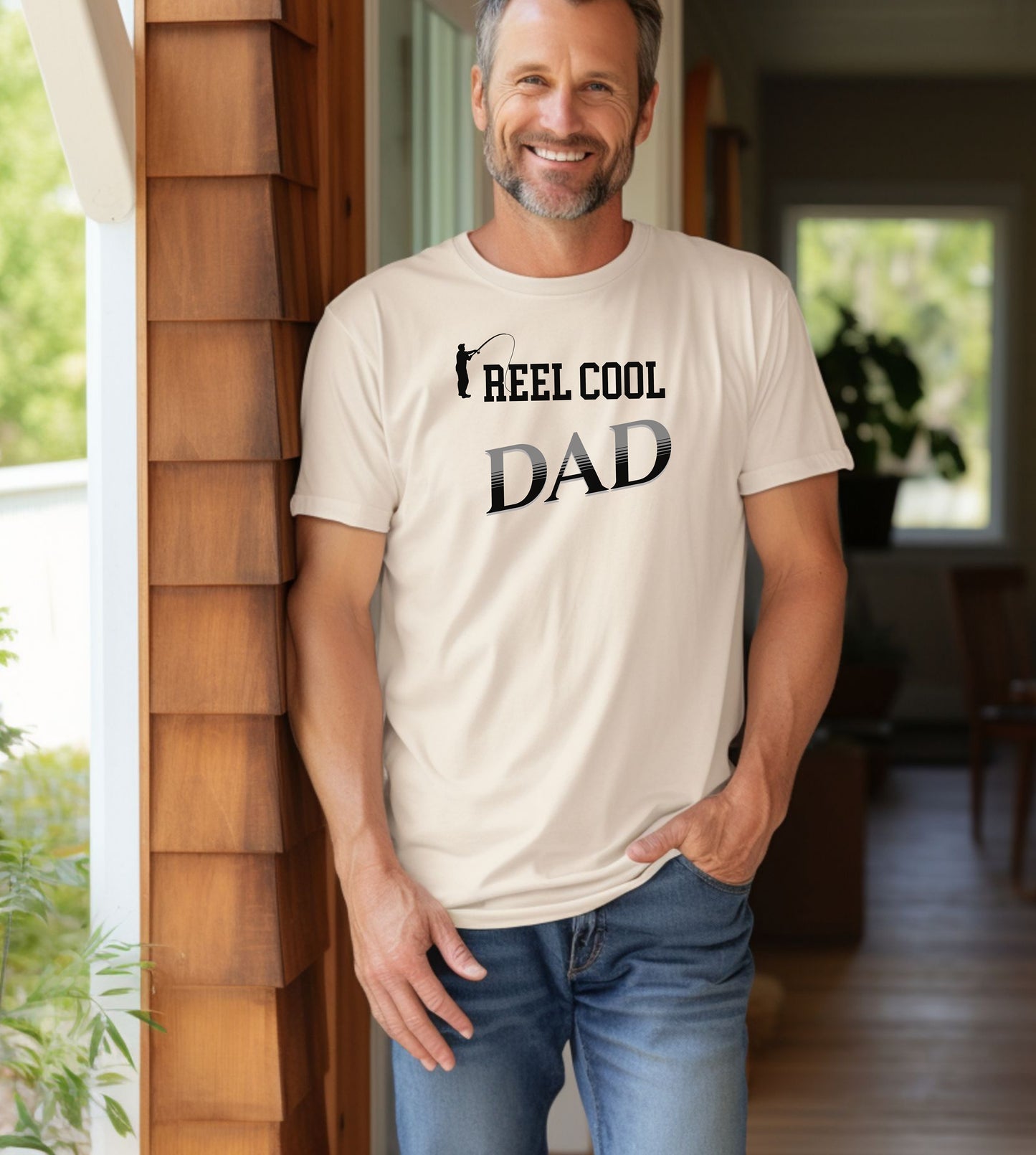 Reel Cool Dad T-shirt featuring a playful fishing-themed design with the phrase 'Reel Cool Dad' and a silhouette of a fisherman casting a line. Printed on an Ivory unisex tee, this fun graphic is perfect for dads who love fishing and spending time outdoors. Ideal for Father’s Day, birthdays, or casual wear for the proud angler dad.