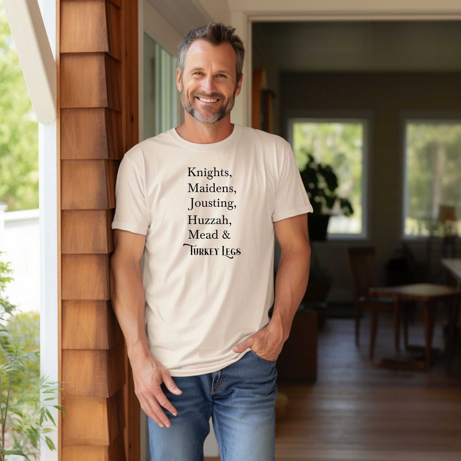 Person wearing an Ivory Renaissance Faire-themed T-shirt featuring a playful list-style text: “Knights, Maidens, Jousting, Huzzah, Mead & Turkey Legs.” The design uses elegant medieval-inspired fonts to celebrate classic faire experiences, perfect for fairgoers who love the festive mix of tradition, adventure, and hearty food.