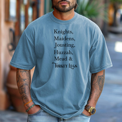 Person wearing a Washed Denim Renaissance Faire-themed T-shirt featuring a playful list-style text: “Knights, Maidens, Jousting, Huzzah, Mead & Turkey Legs.” The design uses elegant medieval-inspired fonts to celebrate classic faire experiences, perfect for fairgoers who love the festive mix of tradition, adventure, and hearty food.