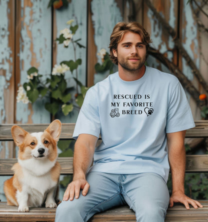 Rescued Is My Favorite Breed T-shirt featuring bold black text with small graphics of a cat, dog, and paw print heart. Printed on a baby blue unisex tee, this design is perfect for animal lovers and rescue advocates. Ideal for showcasing pride in adopting pets and supporting animal rescue efforts, whether worn casually or at adoption events.