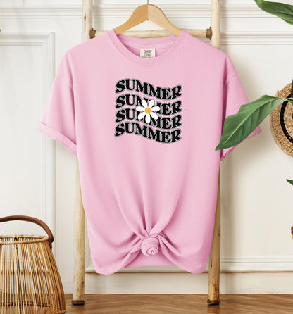 Blossom pink T-shirt featuring a retro wavy text design that repeats the word “SUMMER” four times in bold black vintage-style letters. A large white daisy with a yellow center overlaps the middle of the design, adding a cheerful floral touch. Perfect for sunny days, vacations, and casual outings, this shirt has a nostalgic, laid-back summer vibe.