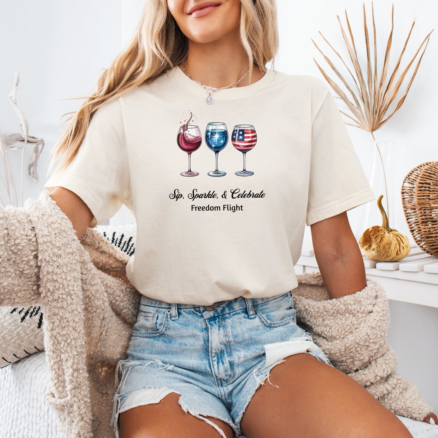 Natural t-shirt featuring a festive 'Sip, Sparkle, & Celebrate – Freedom Flight' design with three wine glasses: one red with sparkles, one blue with stars, and one decorated with the American flag. Perfect for 4th of July, patriotic events, summer parties, and wine lovers celebrating in style.