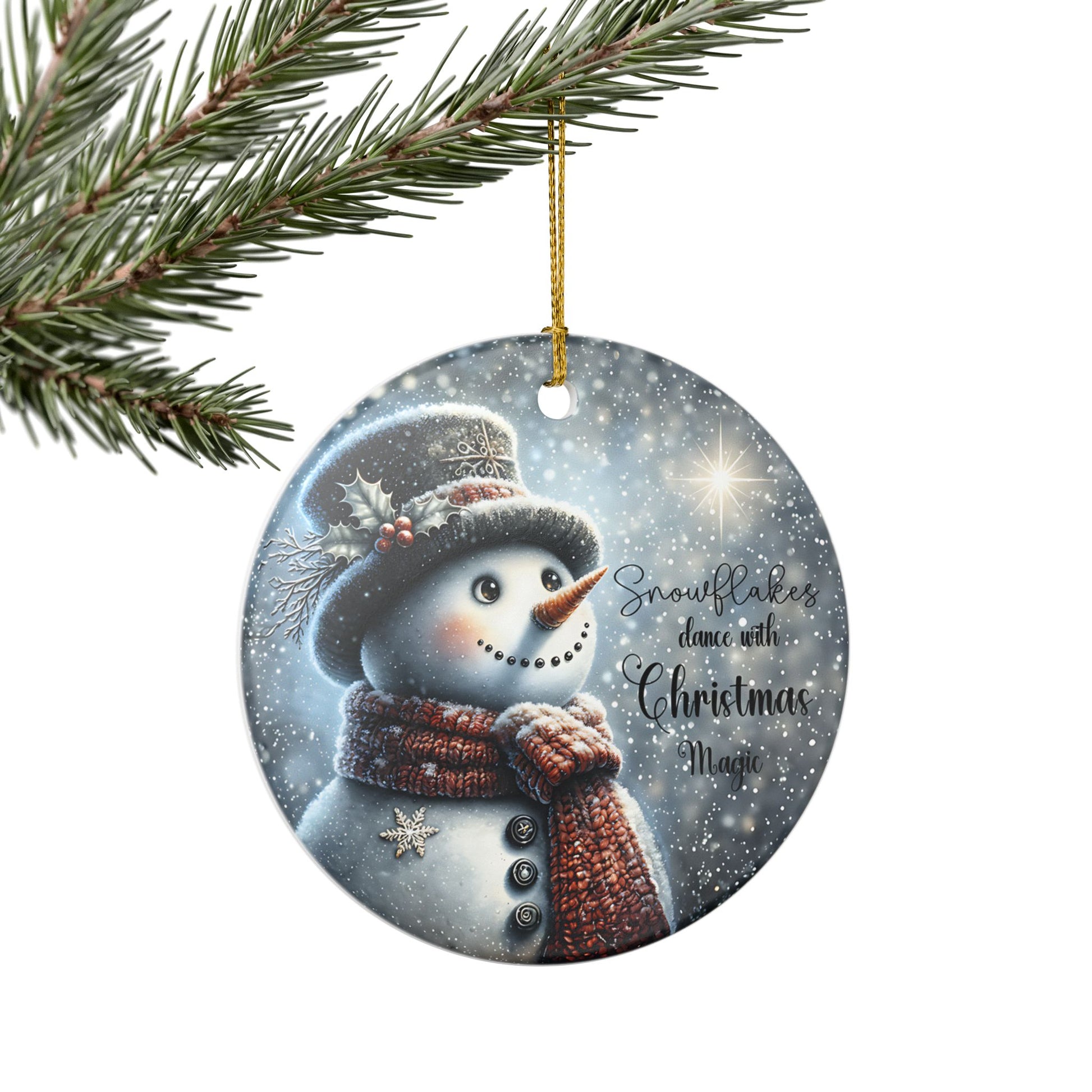 Round ceramic Christmas ornament with a snowman design and festive text, hanging from a tree branch.