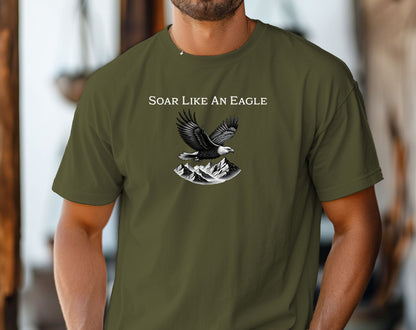 Hemp color T-shirt featuring a bold “Soar Like An Eagle” design with white text above a detailed black and white illustration of a soaring eagle over rugged mountain peaks. The graphic captures strength, freedom, and nature’s beauty, making it perfect for outdoor enthusiasts, adventure lovers, and patriotic spirits. Modeled in a casual, relaxed fit for everyday wear.