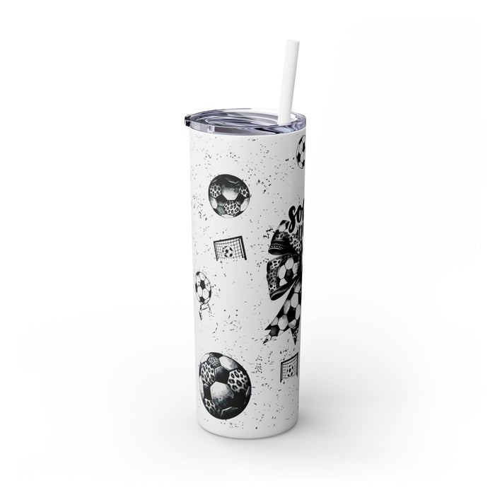Soccer Mom Skinny Tumbler – 20 oz featuring a black-and-white coquette bow made of soccer balls with a leopard print accent. Surrounded by small soccer ball and goal illustrations on a speckled background, this stylish and durable tumbler is perfect for keeping drinks hot or cold. A fun and practical accessory for proud soccer moms to show their team spirit during practices, games, and everyday use.
