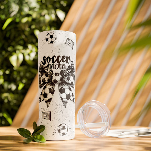 Soccer Mom Skinny Tumbler – 20 oz featuring a black-and-white coquette bow made of soccer balls with a leopard print accent. Surrounded by small soccer ball and goal illustrations on a speckled background, this stylish and durable tumbler is perfect for keeping drinks hot or cold. A fun and practical accessory for proud soccer moms to show their team spirit during practices, games, and everyday use.