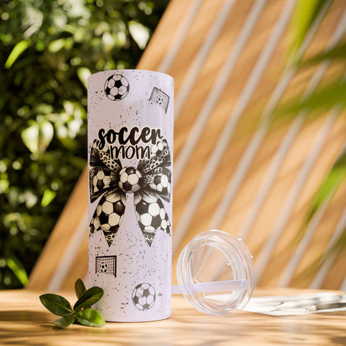 Soccer Mom Skinny Tumbler – 20 oz featuring a black-and-white coquette bow made of soccer balls with a leopard print accent. Surrounded by small soccer ball and goal illustrations on a speckled background, this stylish and durable tumbler is perfect for keeping drinks hot or cold. A fun and practical accessory for proud soccer moms to show their team spirit during practices, games, and everyday use.