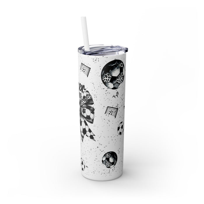 Soccer Mom Skinny Tumbler – 20 oz featuring a black-and-white coquette bow made of soccer balls with a leopard print accent. Surrounded by small soccer ball and goal illustrations on a speckled background, this stylish and durable tumbler is perfect for keeping drinks hot or cold. A fun and practical accessory for proud soccer moms to show their team spirit during practices, games, and everyday use.