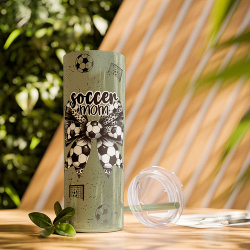 Soccer Mom Skinny Tumbler – 20 oz featuring a black-and-white coquette bow made of soccer balls with a leopard print accent. Surrounded by small soccer ball and goal illustrations on a speckled background, this stylish and durable tumbler is perfect for keeping drinks hot or cold. A fun and practical accessory for proud soccer moms to show their team spirit during practices, games, and everyday use.