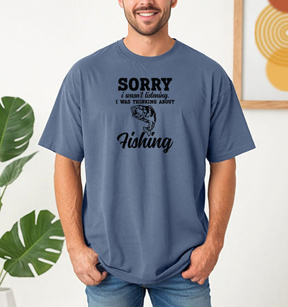 SORRY I wasn’t listening. I was thinking about Fishing' T-shirt featuring bold and script fonts with a detailed fish illustration. Printed on a blue jean unisex tee, this humorous design is perfect for fishing enthusiasts who’d rather be on the water than anywhere else. Ideal for casual wear, fishing trips, or as a fun gift for anglers and dads who love the sport.